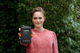 Une personne tenant un produit Husqvarna montrant l’indicateur d’état de la batterie.