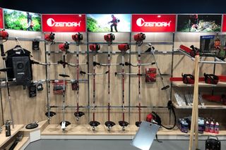 ショールームのウォールラックに取り付けられたさまざまなZenoahガーデニングツールの展示。