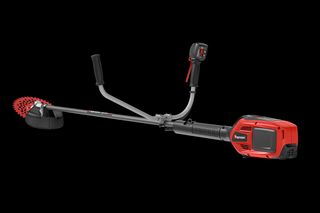 エルゴノミクスのハンドルとカッティングブレードを備えたHusqvarnaブラッシュカッターの側面図。
